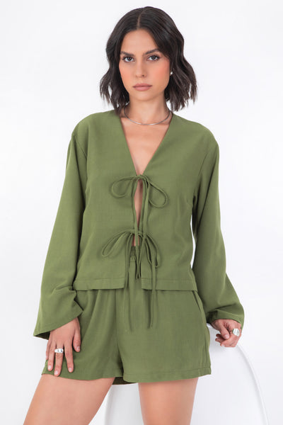 Blusa corta de fit recto, manga larga de puño amplio, escote v y cierre frontal con lazado amarrable.