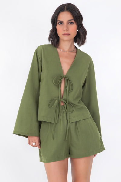 Blusa corta de fit recto, manga larga de puño amplio, escote v y cierre frontal con lazado amarrable.