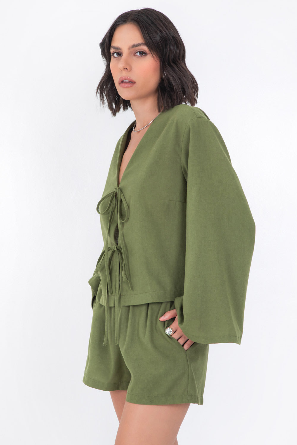 Blusa corta de fit recto, manga larga de puño amplio, escote v y cierre frontal con lazado amarrable.