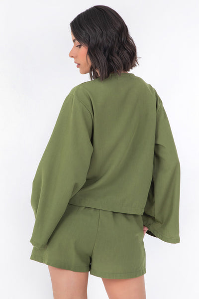 Blusa corta de fit recto, manga larga de puño amplio, escote v y cierre frontal con lazado amarrable.