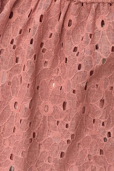 Blusa corta eyelet de manga corta abullonada, rib elástico en cintura, escote redondo con plisados y cierre frontal con lazos amarrables. Detalle de perforado en tejido bordado.