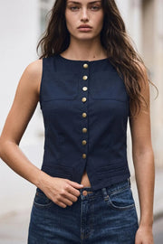 Blusa de fit recto, sin mangas, cuello redondo, bolsillos frontales de parche y costuras decorativas inferiores. Cierre frontal con hilera de botones en contraste.