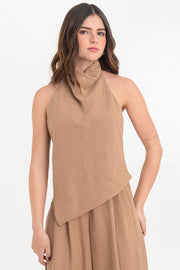 Blusa fluida de cuello alto halter con plisados, sin mangas, escote en espalda y bajo frontal asimétrico. Cierre posterior con broches.
