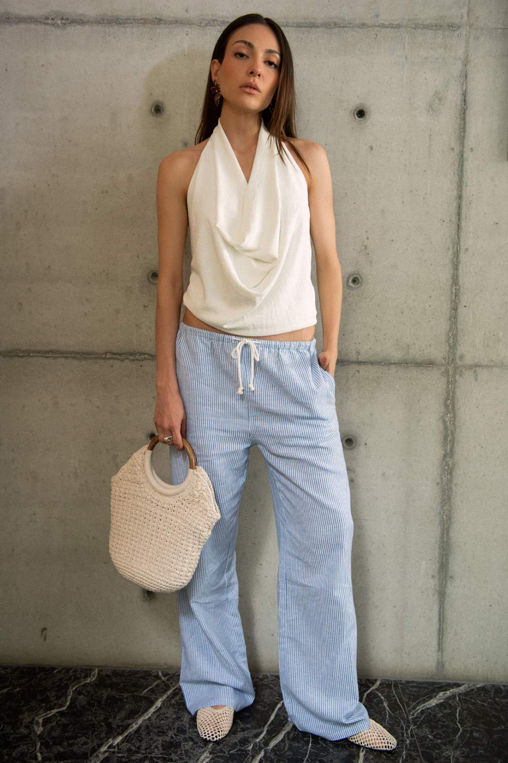 Blusa de cuello halter, escote fluido frontal, sin mangas y escote en espalda.