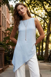 Blusa de cuello redondo, sin mangas, plisados decorativos en costado y bajo diagonal asimétrico.