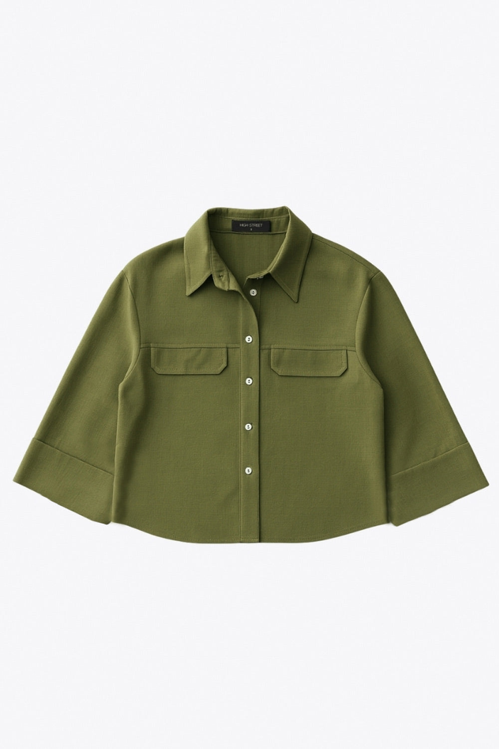 Camisa corta de fit oversized, manga 3/4 amplia con doblez en puños, cuello camisero, bolsillos frontales decorativos con cartera y pinza de amplitud en espalda. Cierre frontal con hilera de botones.