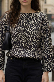 Blusa estampada de fit fluido, manga amplia 3/4, cuello barco y botones decorativos en hombro.