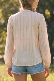 Blusa de fit fluido, estampado rayas, manga larga globo con rib elástico en puños, cuello mao y detalle decorativo frontal con olanes.