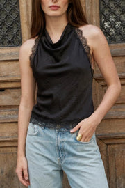 Blusa de cuello halter fluido, escote en espalda con lazo amarrable posterior, cierre con botón y ojal. Detalle de encaje decorativo en sisa y bajo.