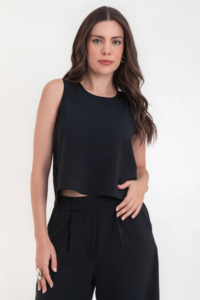 Blusa sin mangas de fit ligeramente oversized, cuello redondo y cierre posterior con botón y ojal.