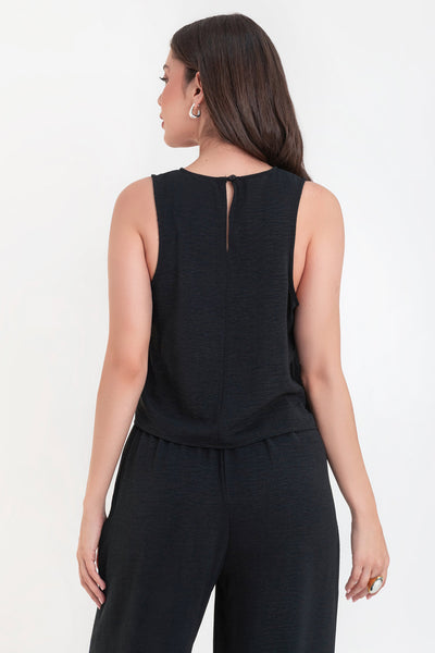 Blusa sin mangas de fit ligeramente oversized, cuello redondo y cierre posterior con botón y ojal.