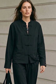 Blusa de manga larga con puño abotonado, fit recto, cuello mao, bolsillos delanteros de parche y cierre frontal con botones alamares.
