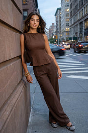 Blusa de bouclé, fit ajustado, sin mangas, cuello barco, cortes frontales y peplum con olanes en bajo.