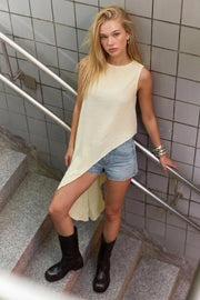 Blusa túnica sin mangas, cuello redondo, bajo asimétrico diagonal y corte en a.