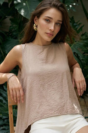 Blusa túnica sin mangas, cuello redondo, bajo frontal asimétrico, corte en a, cierre posterior con botón y ojal. Detalle de plisados en hombros.