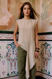 Blusa túnica de fit fluido, manga corta seguida, cuello redondo, detalle decorativo asimétrico en bajo lateral, cierre posterior con botón y ojal.