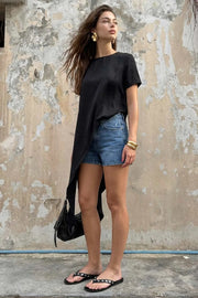 Blusa de fit recto, manga corta, cuello redondo y bajo diagonal asimétrico.