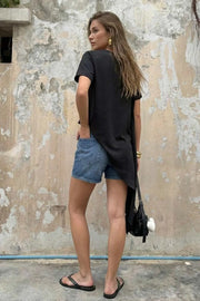 Blusa de fit recto, manga corta, cuello redondo y bajo diagonal asimétrico.