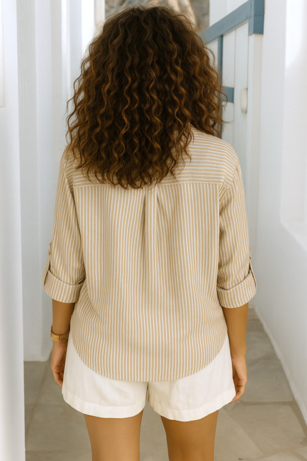 Camisa corta de estampado rayas, fit recto, manga larga rolled up con trabilla ajustable, cuello camisero, cruce frontal con escote v y nudo decorativo en bajo. Detalle de bajo curveado y pinza de amplitud en espalda.