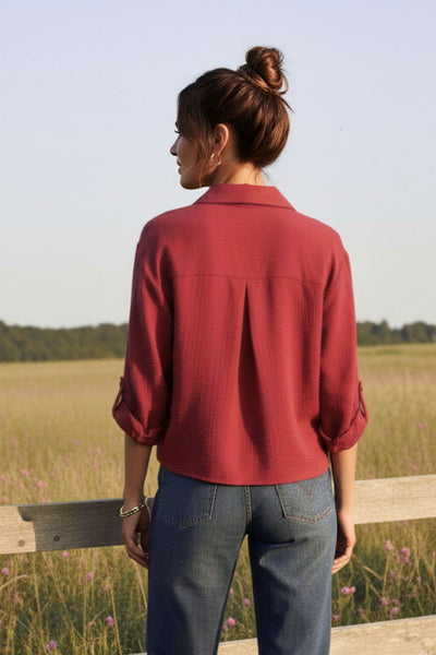 Camisa corta de fit recto, manga larga rolled up con trabilla ajustable, cuello camisero, cruce frontal con escote v y nudo decorativo en bajo. Detalle de bajo curveado y pinza de amplitud en espalda.