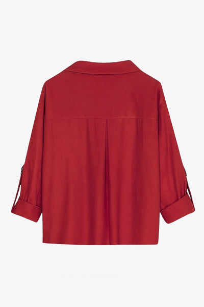 Camisa corta de fit recto, manga larga rolled up con trabilla ajustable, cuello camisero, cruce frontal con escote v y nudo decorativo en bajo. Detalle de bajo curveado y pinza de amplitud en espalda.