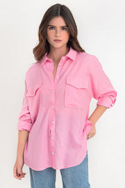 Camisa de lino, fit oversized, cuello camisero, manga larga con puño abotonado y trabillas ajustables, bolsillos frontales de parche con cartera y bajo curveado. Cierre frontal con hilera de botones.