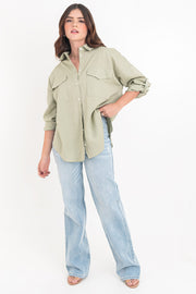 Camisa de lino, fit oversized, cuello camisero, manga larga con puño abotonado y trabillas ajustables, bolsillos frontales de parche con cartera y bajo curveado. Cierre frontal con hilera de botones.