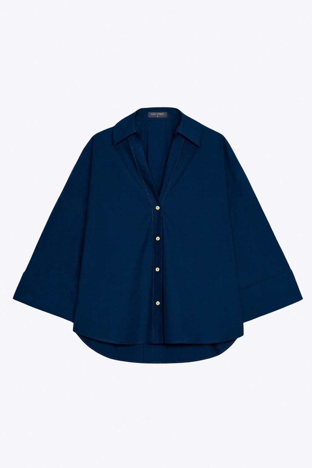 Camisa de fit oversized, manga 3/4 amplia con doblez en puños, cuello camisero, escote v, pinza de amplitud en espalda con trabilla decorativa y bajo curveado. Cierre frontal con hilera de botones en contraste.