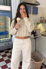 Camisa corta de estampado cuadros, cuello camisero, manga larga con puño abotonado, fit abullonado y bolsillo frontal. Cierre frontal con hilera de botones, pinza de amplitud en espalda y rib elástico en bajo.