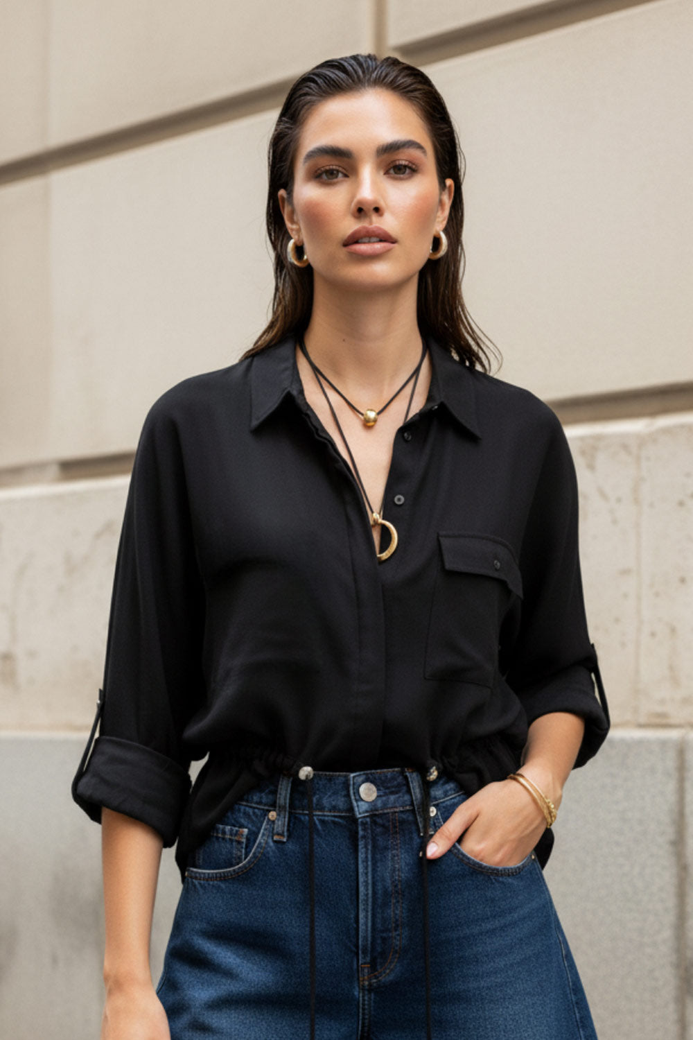 Camisa de fit oversized, manga larga amplia rolled up con trabillas y botón en contraste, cuello camisero y jareta ajustable en cintura. Cierre frontal con hilera oculta de botones.