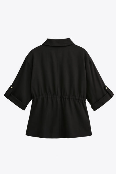 Camisa de fit oversized, manga larga amplia rolled up con trabillas y botón en contraste, cuello camisero y jareta ajustable en cintura. Cierre frontal con hilera oculta de botones.