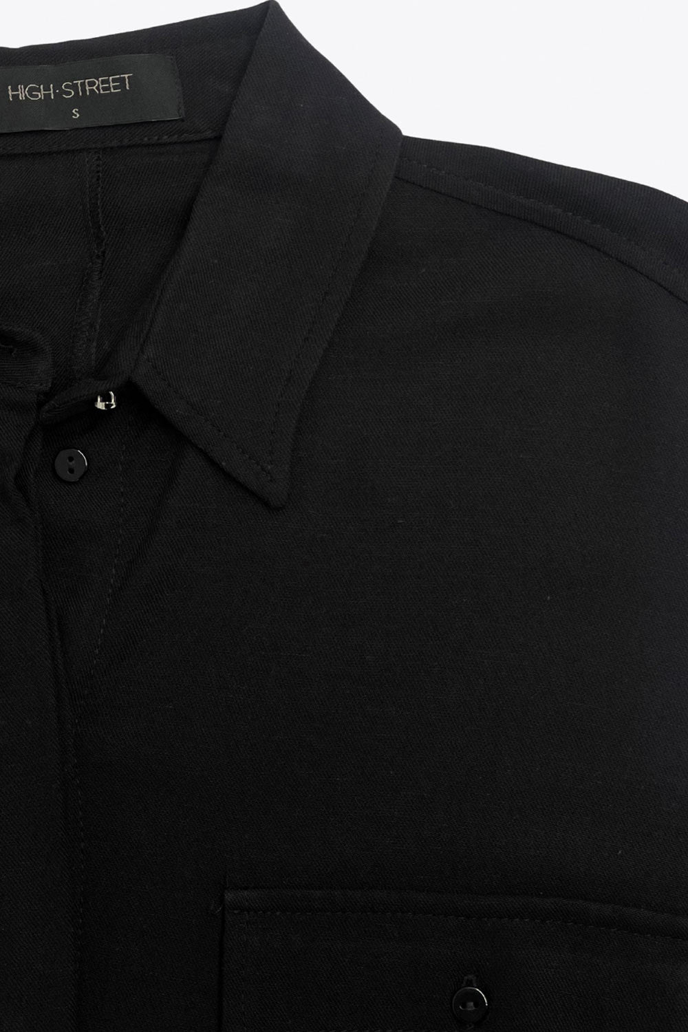 Camisa de fit oversized, manga larga amplia rolled up con trabillas y botón en contraste, cuello camisero y jareta ajustable en cintura. Cierre frontal con hilera oculta de botones.