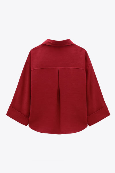 Camisa corta de fit oversized, manga 3/4 amplia con doblez en puños, cuello camisero, bolsillos frontales decorativos con cartera y pinza de amplitud en espalda. Cierre frontal con hilera de botones.
