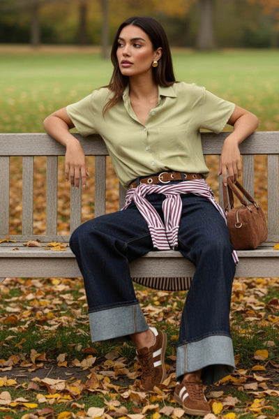 Camisa corta de lino, fit recto, manga corta, cuello camisero, bolsillo frontal de parche, bajo curveado con aberturas laterales y cierre frontal con hilera de botones.