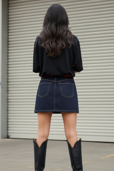 Camisa corta de lino, fit recto, manga corta, cuello camisero, bolsillo frontal de parche, bajo curveado con aberturas laterales y cierre frontal con hilera de botones.