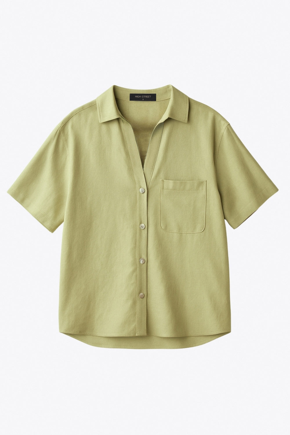 Camisa corta de lino, fit recto, manga corta, cuello camisero, bolsillo frontal de parche, bajo curveado con aberturas laterales y cierre frontal con hilera de botones.