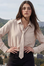 Camisa de fit oversized, estampado rayas, cuello camisero, manga larga con puño abotonado, pinza de amplitud en espalda, bolsillo frontal, bajo curveado y cierre frontal con hilera de botones. Detalle de corbata del mismo tejido.