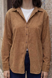 Camisa de pana, fit oversized, cuello camisero, manga larga con puño abotonado y bajo curveado. Cierre frontal con hilera de botones en contraste.