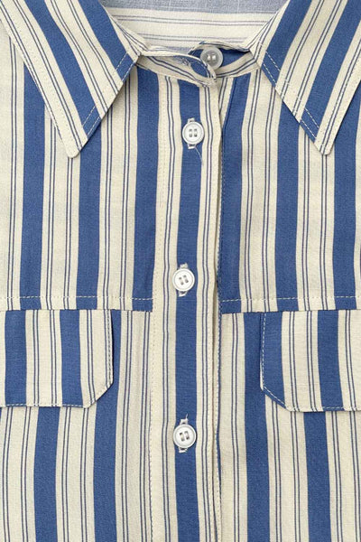 Camisa corta de estampado rayas, fit oversized, manga 3/4 amplia con doblez en puños, cuello camisero, bolsillos frontales decorativos con cartera y pinza de amplitud en espalda. Cierre frontal con hilera de botones.