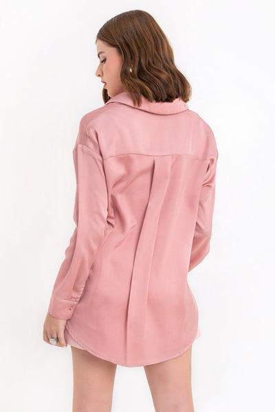 Camisa satinada de fit ligeramente oversized, manga larga con puño abotonado, cuello camisero, bajo curvado y cierre frontal con hilera de botones.