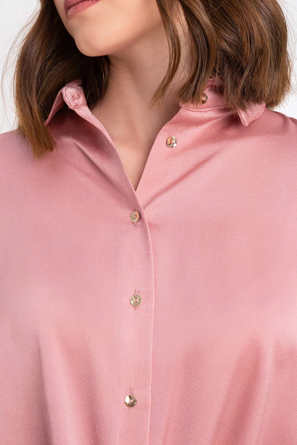 Camisa satinada de fit ligeramente oversized, manga larga con puño abotonado, cuello camisero, bajo curvado y cierre frontal con hilera de botones.