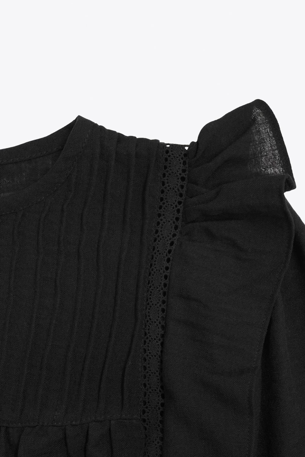 Camisa de fit amplio, costuras decorativa frontales con plisados, manga larga abullonada con rib elástico en puños, cuello redondo, olanes decorativos en sisa, cierre posterior con botón y ojal.