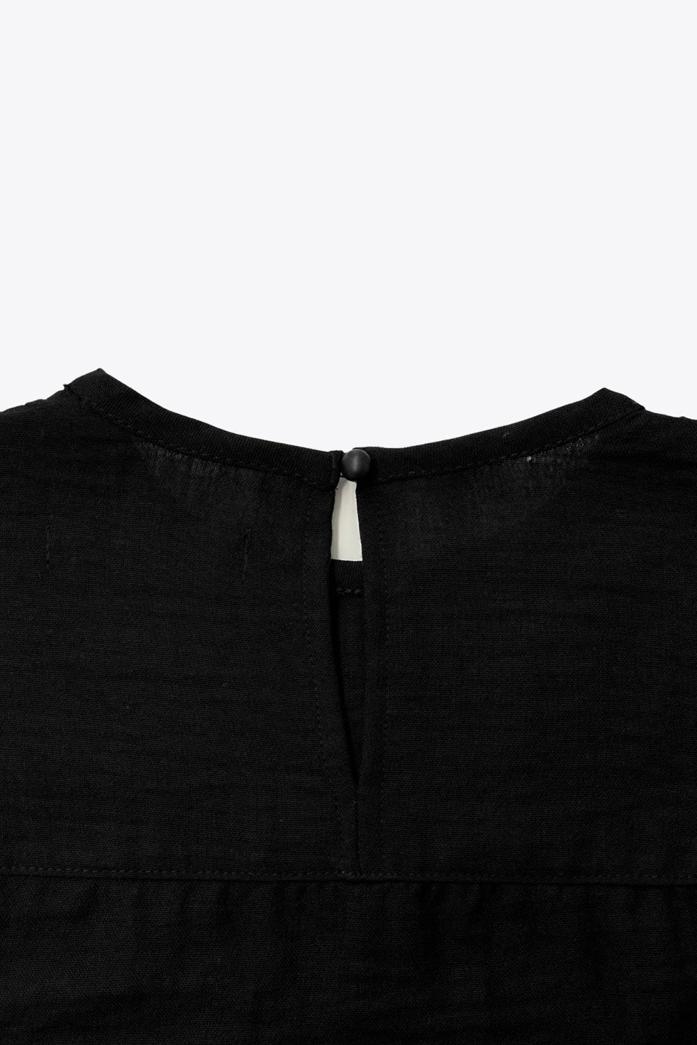 Camisa de fit amplio, costuras decorativa frontales con plisados, manga larga abullonada con rib elástico en puños, cuello redondo, olanes decorativos en sisa, cierre posterior con botón y ojal.