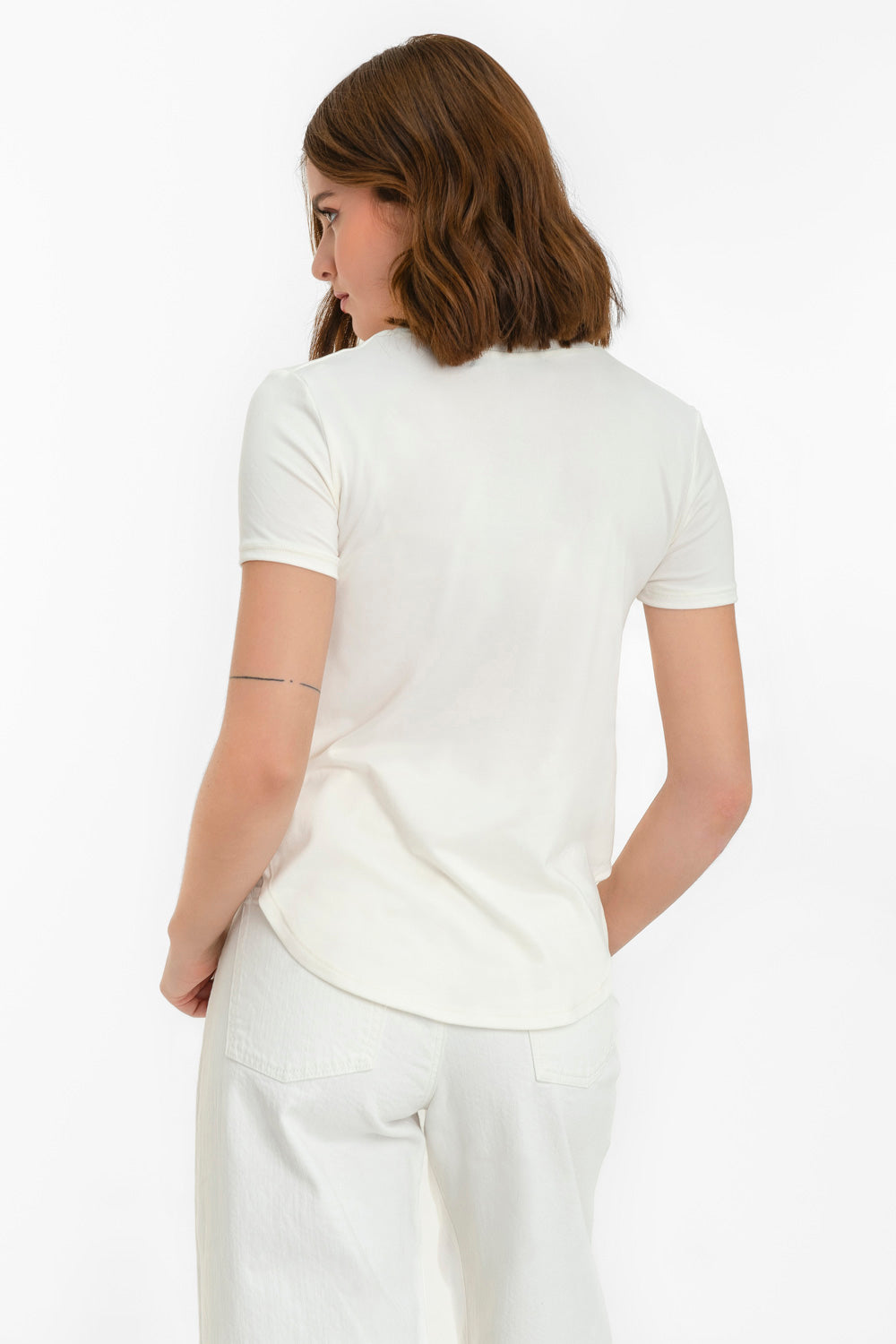 Camiseta silueta fluida, cuello redondo y manga corta. Detalle de bajo curveado.