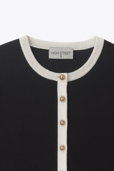 Cardigan de punto, fit recto, manga larga con rib de contraste en puños, bajo y cuello redondo. Cierre frontal con hilera de botones en contraste.