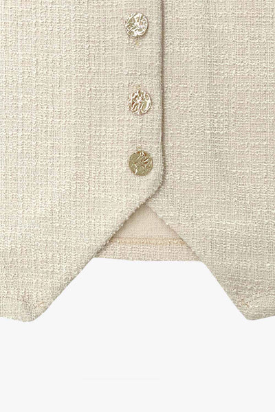 Chaleco de bouclé, fit recto, escote v, cierre con hilera de botones en contraste y abertura frontal v en bajo.