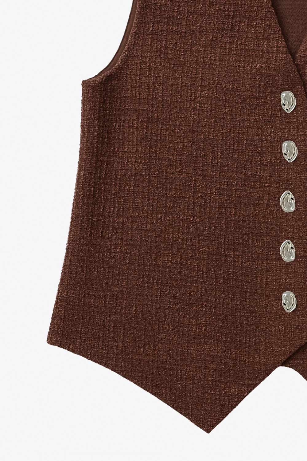 Chaleco de bouclé, fit recto, escote v, cierre con hilera de botones en contraste y abertura frontal v en bajo.