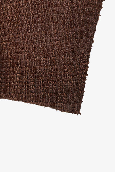 Chaleco de bouclé, fit recto, escote v, cierre con hilera de botones en contraste y abertura frontal v en bajo.