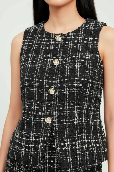 Chaleco de bouclé fit ajustado, cuello redondo, vivos decorativos frontales, cierre con hilera de botones en contraste y abertura frontal en bajo.