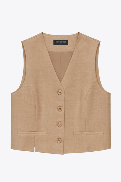 Chaleco corto de fit recto, escote v, vivos decorativos, pinzas frontales y aberturas en bajo. Detalle de trabilla ajustable posterior con hebilla y cierre frontal con hilera de botones en contraste.